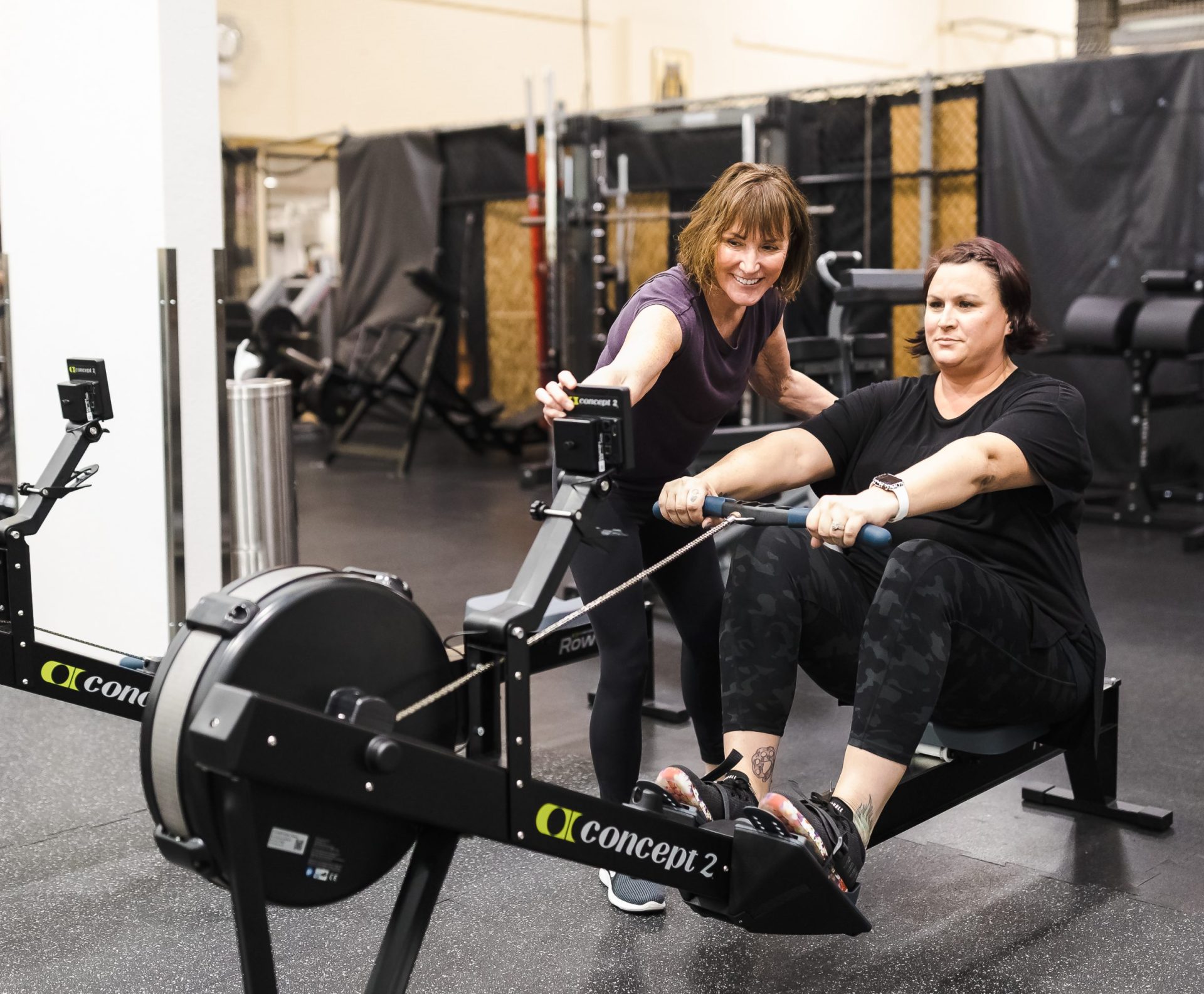 Personal Trainer explaining a workout on the rowing machine to her client.