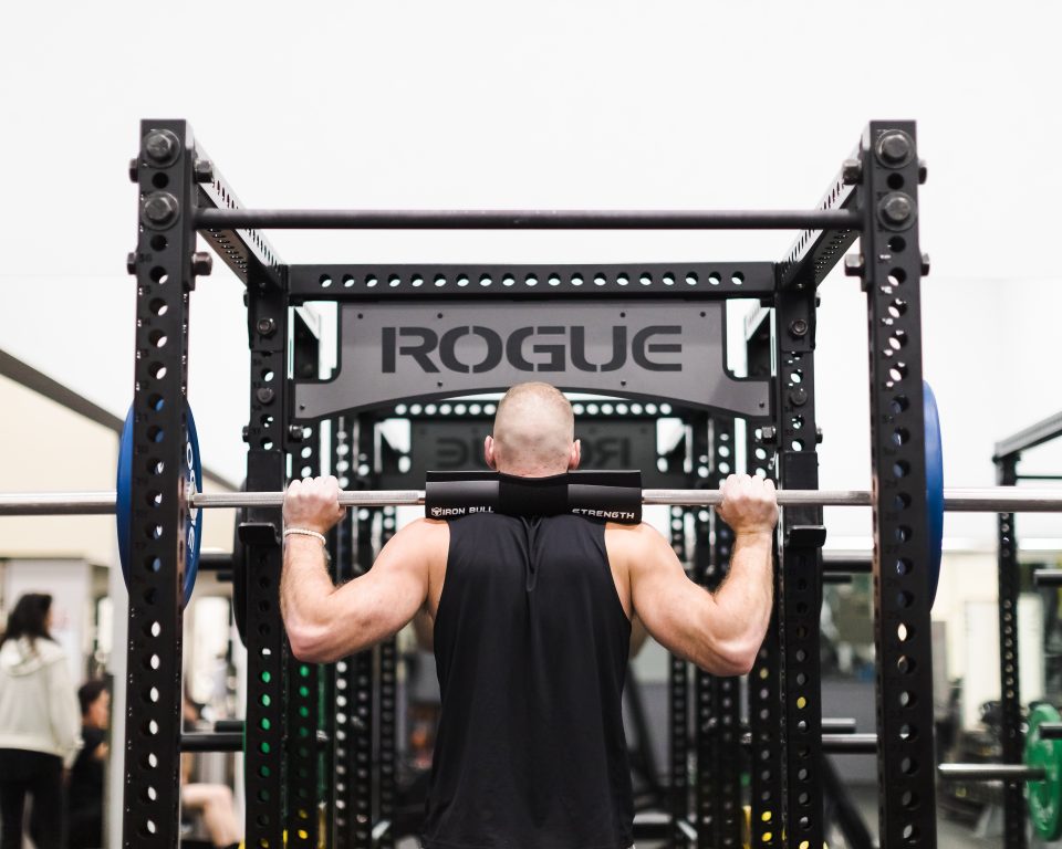 Gym member using a Rogue squat rack